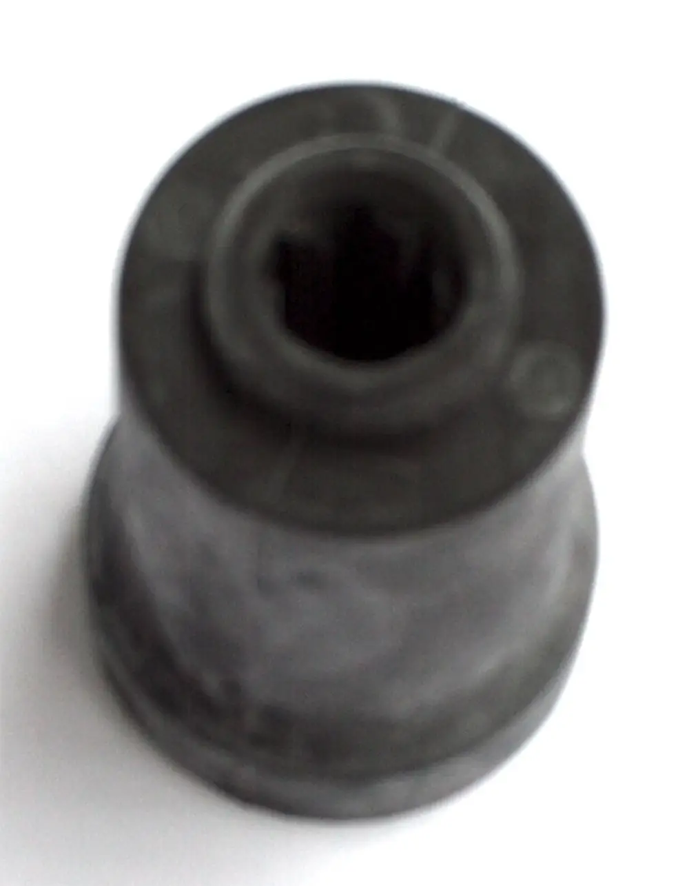 Daikin Schwingungsisolator in schwarzer Farbe, zylindrische Form mit eingekerbtem Innenprofil, auf hellem Hintergrund.